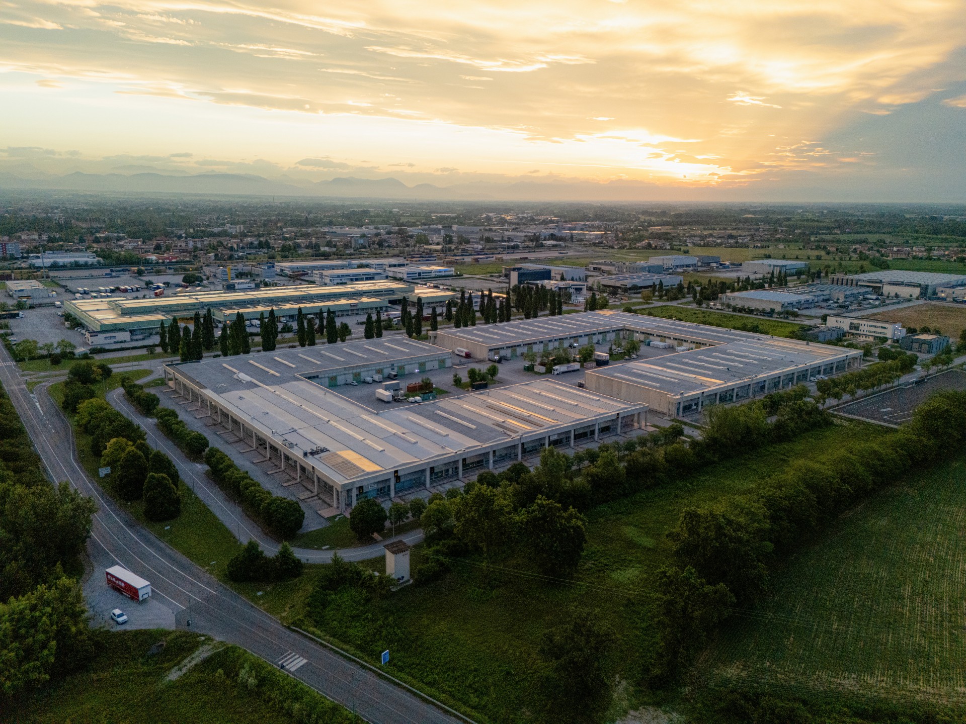 Veduta dal drone del Centro Merci dell'Interporto di Pordenone, con la torre gialla e il piazzale dei parcheggi